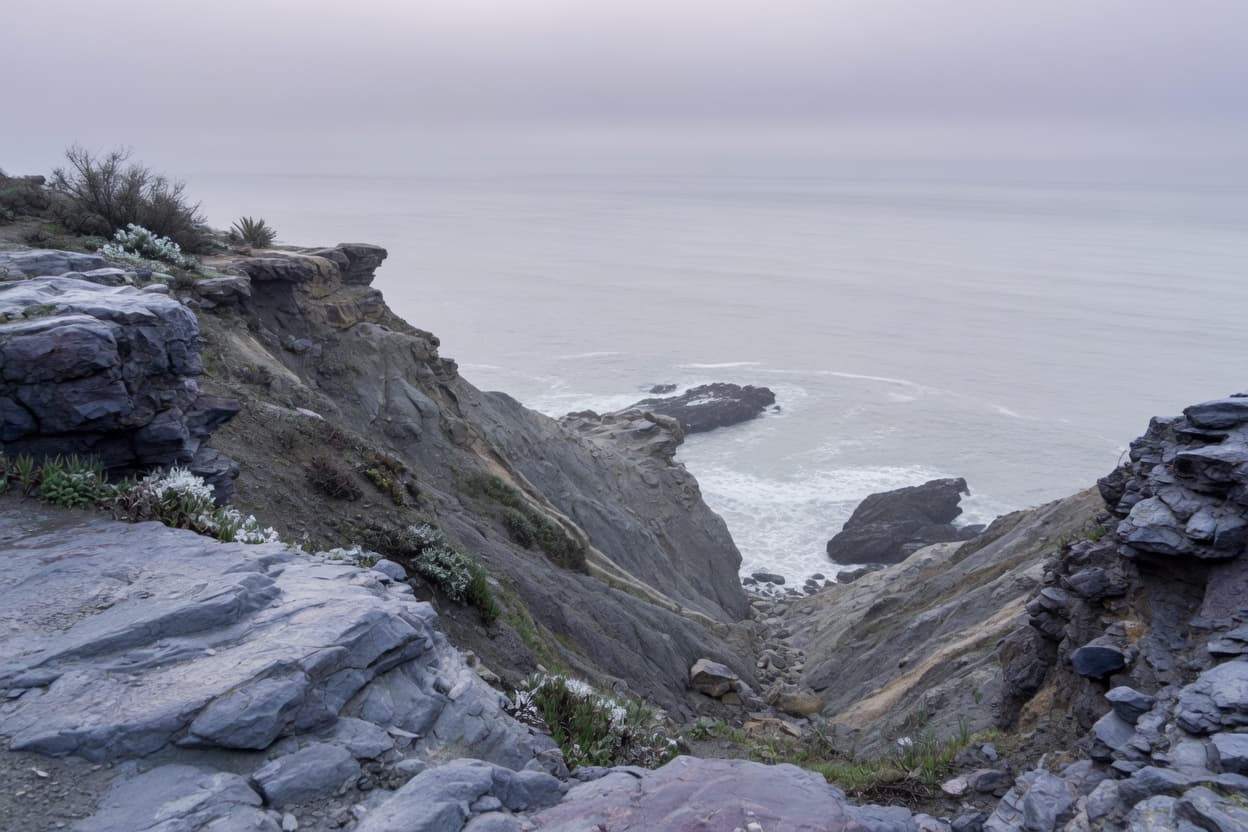 Overcast Southern California coastline, rock and pale water