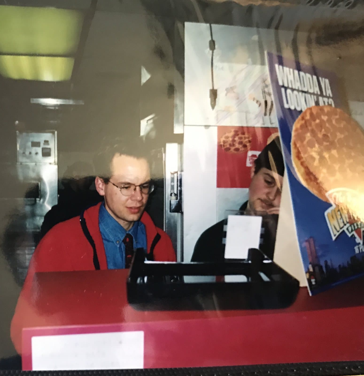 A 1990s photograph of a young Rob Stickler in uniform behind a Pizza Hut front counter
