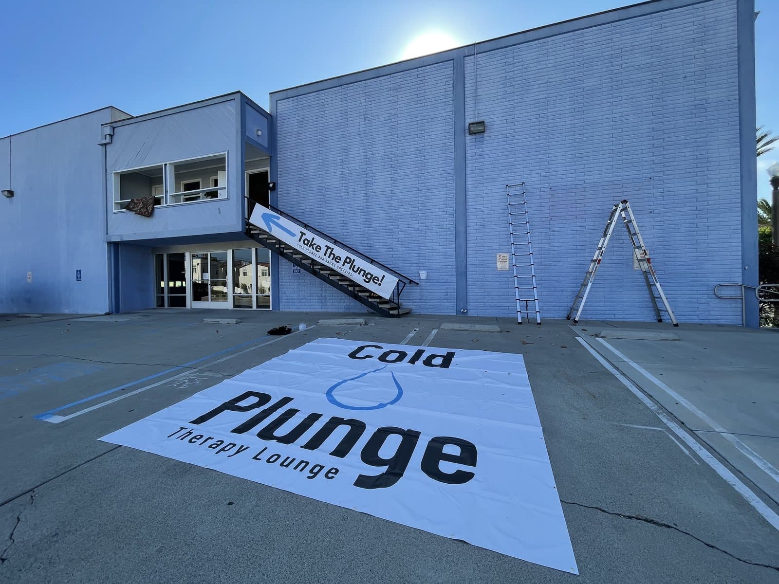 A storefront sign laid flat on the pavement before installation